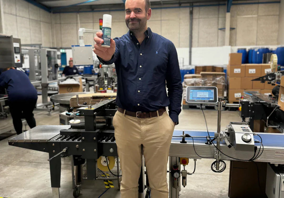 Thomas Laird, MD of Salt of the Earth, holding Ocean & Coconut natural deodorant spray at the end of production line